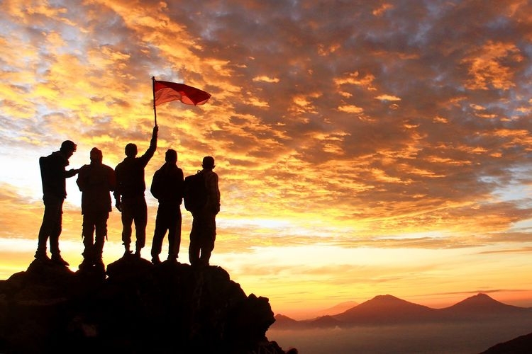 Ilustrasi pemuda. Sekelompok anak muda memegang bendera merah putih di puncak gunung, menatap matahari terbit.| Sumber: Shutterstock/Triawanda Tirta Aditya via Kompas.com
