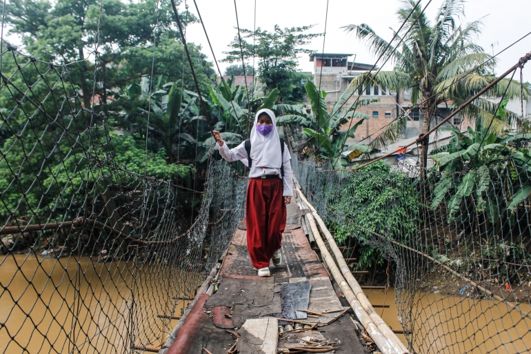 Seorang pelajar melintasi jembatan gantung Srengseng Sawah, Jakarta Selatan. (Jonas/Mahasiswa)