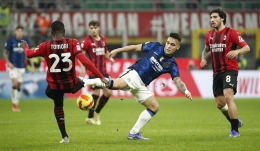 Pemain AC Milan Tomori dan Tonali memblok tendangan volly penyerang Inter Lautaro Martinez. Foto: Alessandro Garevalo / Reuters