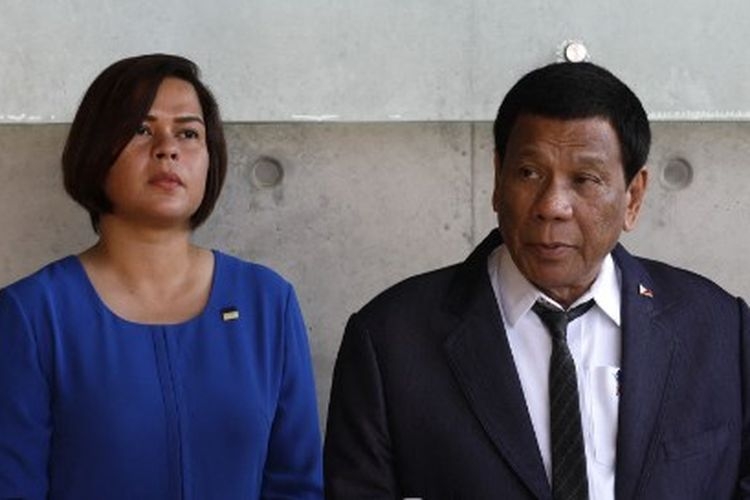 Presiden Filipina Rodrigo Duterte (kanan) memberi isyarat bahwa putrinya, Sara Duterte-Carpio (kiri), akan mencalonkan diri sebagai presiden dalam pemilihan 2022. (Foto: AFP PHOTO/GALI TIBBON)
