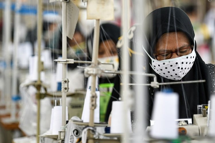 Ilustrasi seorang pekerja sedang memproduksi alat pelindung diri (APD) di sebuah perusahaan garmen. Sumber: Antara Foto/M Risyal Hidayat