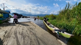Dermaga Desa Olu di kejauhan dan beberapa kapal nelayan danau yang terparkir di tepi Danau Lindu, Sulawesi Tengah. (@Hanom Bashari) 