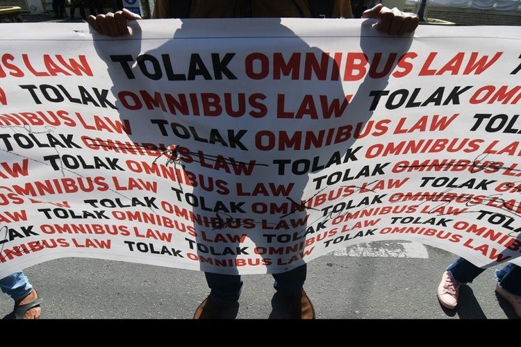Pengunjuk rasa yang tergabung dalam Front Rakyat Tolak Omnibus Law (Frontal) membawa spanduk saat melakukan aksi unjuk rasa di Depan Gedung DPRD Sulawesi Tengah di Palu, Sulawesi Tengah, Jumat (14/8/2020). (ANTARA FOTO/MOHAMMAD HAMZAH)