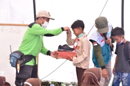 Manajer SDM LAZ Harfa, II Irfan menyerahkan langsung donasi sepatu baru kepada anak-anak di pengungsian