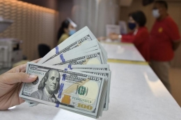 Karyawan menunjukkan mata uang Dolar Amerika Serikat. (Foto: Republika)