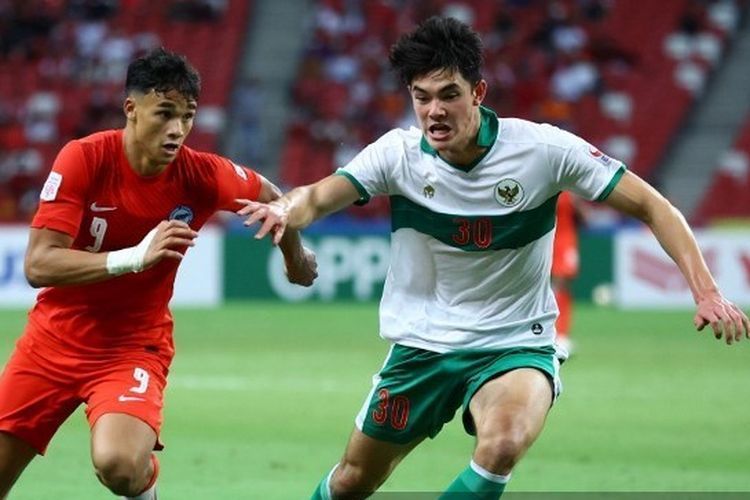 Pemain timnas Singapura, Ikhsan Fandi, berduel dengan bek Indonesia, Elkan Baggott, dalam laga leg pertama semifinal Piala AFF 2020.(AFP/GETTY IMAGES/YONG TECK LIM via Kompas.com 