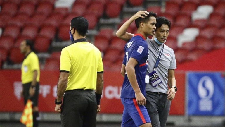 Safuan Baharudin, bek Singapura yang mendapat kartu merah, dihibur pelatih Tatsuma Yoshida (Foto AP/Suhaimi Abdullah). 