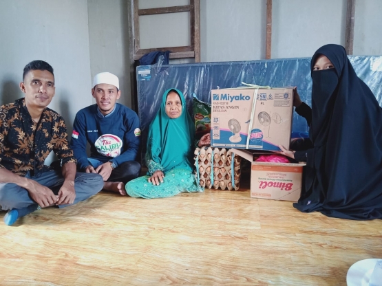 Isteri Kakek Husein menerima bantuan sembako dan peralatan rumah tangga dari relawan. (Foto : FB grup Poros Kebijakan Indragiri Hilir)