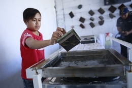 Seorang difabel bernama Asrul, tengah serius mencetak batik. | Dokumentasi Ariyono Setiawan (pendiri Batik Wistara)