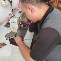 Teguh sedang fokus menjahit masker batik yang menjadi salah satu andalan Rumah Batik Wistara. | Dokumentasi Ariyono Setiawan (pendiri Batik Wistara)
