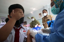 Tenaga kesehatan menyuntikan vaksinasi Covid-19 kepada pelajar di SDN 03 Rawa Buntu, Serpong, Tangerang Selatan, Banten, Selasa (14/12/2021).| Sumber: ANTARA FOTO/MUHAMMAD IQBAL