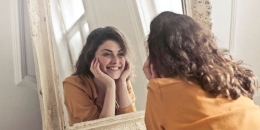 Seseorang yang bahagia di depan dirinya sendiri melalui cermin | Gambar diambil dari lifestyle.kompas.com