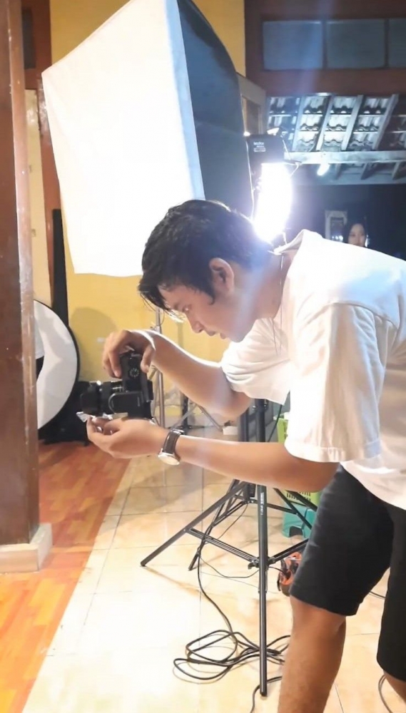 Tekun –  Dhimas M.R ketika menjepret foto di studionya. Keniten, Ponorogo Selasa (14/12)