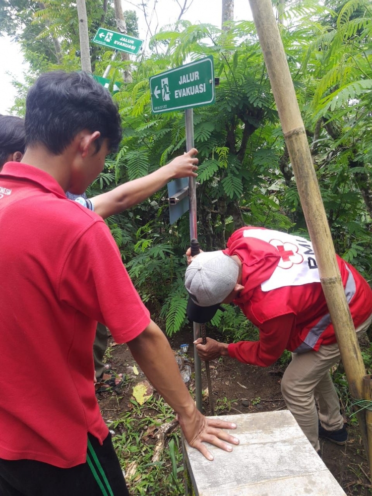 Proses pemasangan tiang rambu jalur evakuasi oleh mahasiswa KKN UM bersama SIBAT (Dokpri)