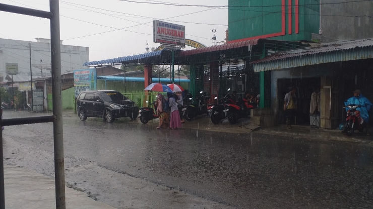 Anak dan Emaknya saat hujan deras di Jl. SM Raja Kisaran, Asahan. Foto Dokumen Pribadi