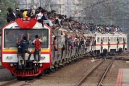 Suasana orang-orang memenuhi kereta hingga ke atap dan sekeliling kereta. (Source: Indozone)