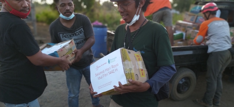 Volunteer Pemuda Peduli tengah membagikan sembako jelang Hari Raya Idul Fitri dalam Program 