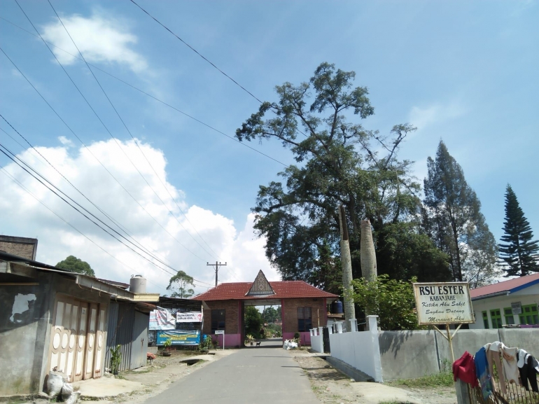 Gerbang masuk desa Lingga dan kantor kepala desa di bawah pohon kayu kuda-kuda (Dokumentasi Pribadi)