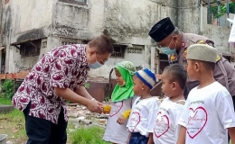 Anggota DPR-RI Darmadi Durianto didampingi Bhabinkamtibmas Tanah Sereal Aiptu  Rois Roesito memberikan santunan kepada anak yatim (Foto:istimewa)
