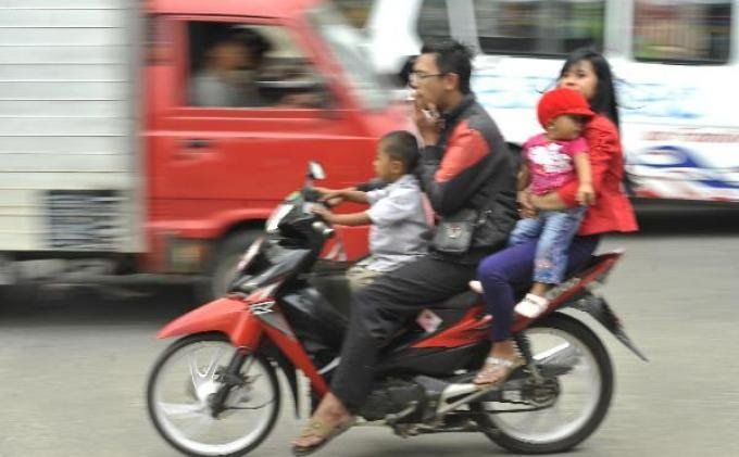 Pengendara sepeda motor yang tidak pakai helm. Gambar via Tribunnews.com