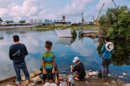 Sejumlah warga memanfaatkan waktu sore dengan melakukan kegiatan memancing di aliran sungai Gedung Pompa Muara Baru, Jakarta Utara. (Jonas/Mahasiswa)