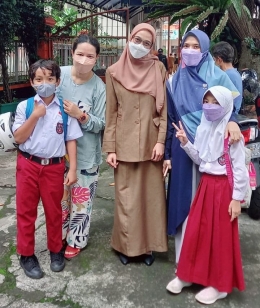 Bu Mitta salah seorang wali kelas di SDN 113 Banjarsari saat mengantar murid ke pintu sekolah dan menemui orang tua murid yang menjemput (Dokpri)