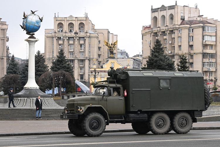 Sebuah kendaraan kargo militer melaju di tengah kota Kiev, Ukraina, Kamis (24/2/2022). Sirene serangan udara berdengung di Kiev setelah perang Rusia vs Ukraina terjadi.(AFP/DANIEL LEAL)