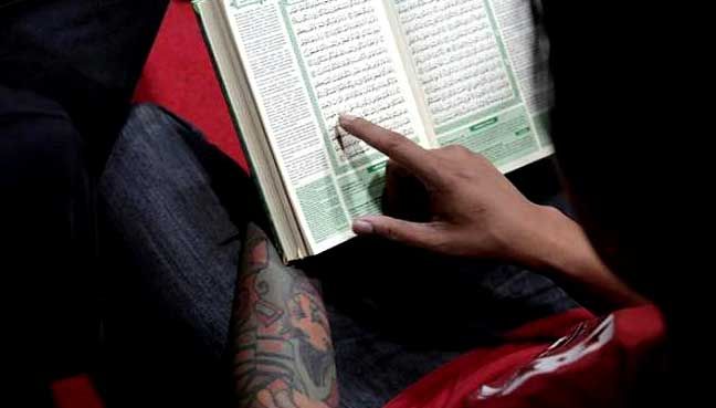 Seorang anggota punk muslim belajar membaca Alquran di rumah komunitas mereka. Sumber gambar: reuters.com/Beawiharta