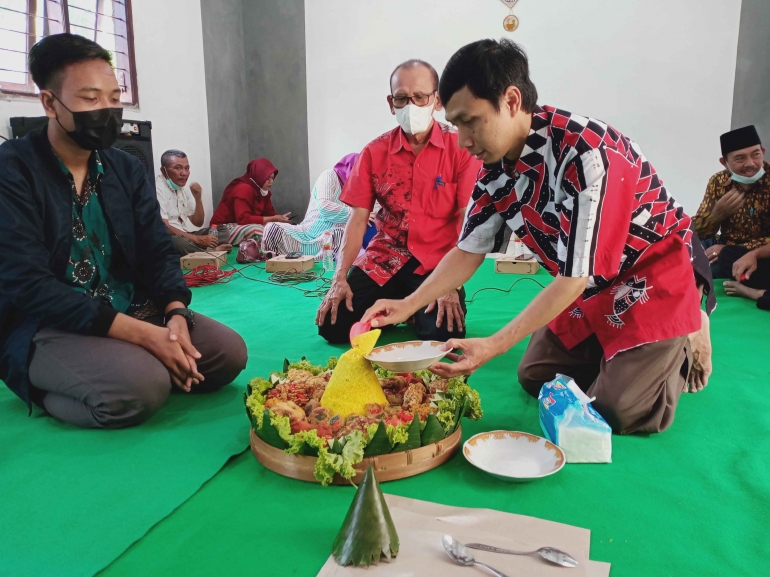 Gambar: Pemotongan tumpeng oleh ketua KKN-P 40 Umsda, DPL dan kepala Desa Watutulis (Dokpri)