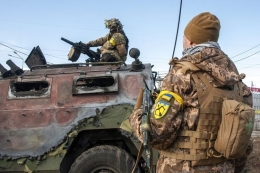 Tentara Ukraina memeriksa kendaraan militer yang rusak setelah pertempuran di Kharkiv, Ukraina, Minggu (27/2/2022). Pemerintah kota mengatakan bahwa pasukan Ukraina terlibat dalam pertempuran dengan pasukan Rusia yang memasuki kota terbesar kedua di negara itu pada Minggu.(AP PHOTO/MARIENKO ANDREW via KOMPAS.com)