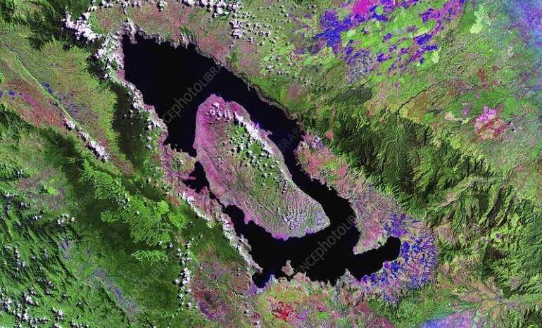 Citra satelit Pulau Samosir (tengah) dan dataran Uluan (sebelah kanan Samosir, dipisahkan Selat Lontung). Bagian warna pink (barat/barat laut Samosir dan timur/tenggara Uluan) adalah lahan landai/datar terbuka yang kini menjadi persawahan (Foto: NASA/Science Photo Library via sciencephoto.com)