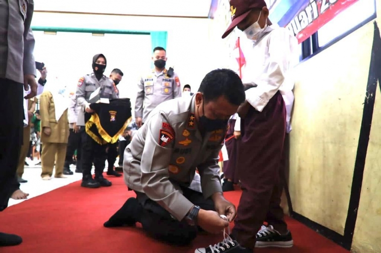 Kapolda Banten memakaikan sepatu murid SD Negeri Ujung Tebu 3, Desa Ujung Tebu, Kecamatan Ciomas, Kabupaten Serang. Foto: Dok Polda Banten