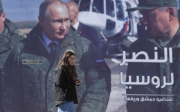 Seorang wanita melewati papan reklame yang menunjukkan Putin di Damaskus, Suriah, Senin, 7 Maret 2022 Foto : TimesSofie.isr.com. 