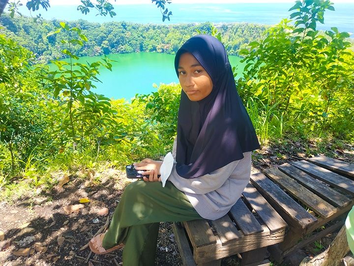 Putri berpose dengan baground Danau Tolire Besar (Dokpri)