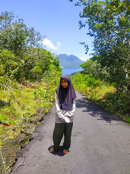 Putriku berpose di jalan menuju objek wisata Pulo Tareba dengan baground Pulau Hiri (Dokpri)