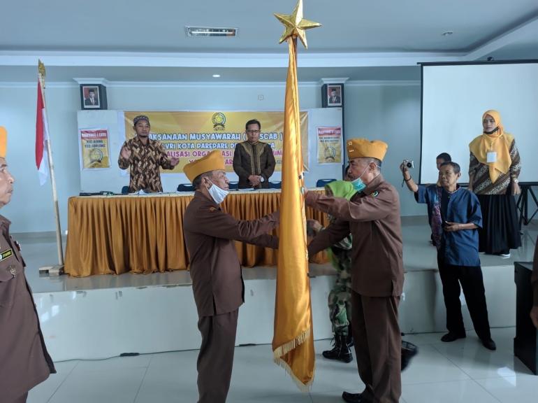 Ketua LVRI Parepare, Piter Pasande menerima bendera LVRI secara simbolis dari Ketua DPD LVRI Sulsel, Jacob Pakilaran. (Foto : Asri Mursyid)