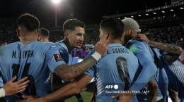 Pemain Uruguay merayakan setelah gol Giorgian De Arrascaeta ke gawang Peru selama pertandingan sepak bola kualifikasi Amerika Selatan untuk Piala Dunia FIFA Qatar 2022, di Stadion Centenario di Montevideo pada 24 Maret 2022.| Sumber: Raul MARTINEZ/POOL/AFP via Tribunnews.com