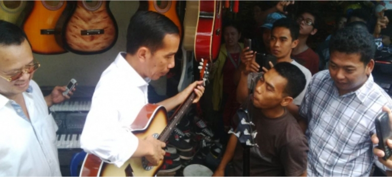 Jokowi bergitar (foto m.merdeka.com)