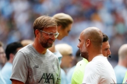 Manajer Liverpool, Juergen Klopp, berbicara dengan pelatih Manchester City, Pep Guardiola (AFP/ADRIAN DENNIS via KOMPAS.com)