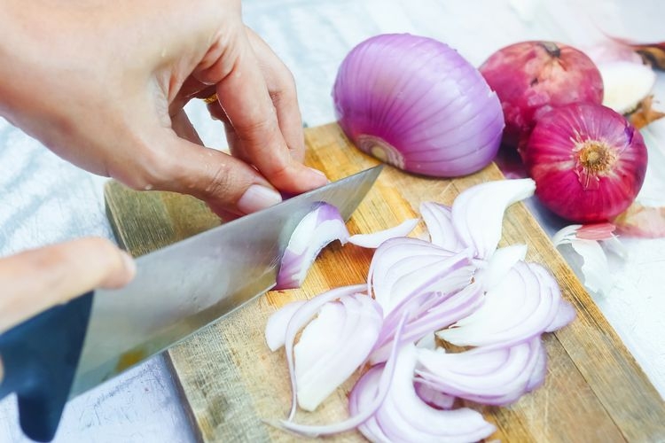 Ilustrasi orang memotong bawang merah.  (sumber: SHUTTERSTOCK/AKIDS.PHOTO.GRAPHY via kompas.com)