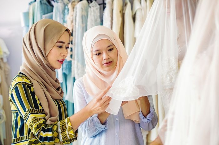 Memilih bahan untuk baju lebaran.| NicolasMcComber/Getty Images via parapuan.co