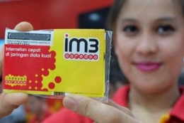 Model memamerkan kartu perdana Indosat IM3 yang kini berubah nama menjadi IM3 Ooredoo.(Reska Koko/Kompas.com)