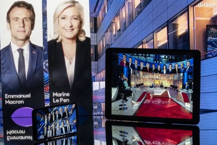 Foto yang diambil di Toulouse, Perancis, pada Minggu (10/4/2022) ini menunjukkan layar yang menampilkan acara televisi yang menunjukkan hasil yang diproyeksikan setelah penutupan tempat pemungutan suara pada putaran pertama pemilihan presiden Prancis. (AFP/LIONEL BONAVENTURE via kompas.com)