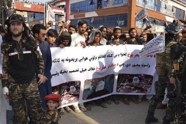 Demonstran memegang spanduk selama protes terhadap serangan udara Pakistan, di Khost pada 16 April 2022. Sumber: AFP via Tribunnews.com