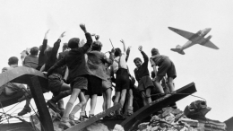 Sejumlah Anak-anak di Kota Berlin ketika menunggu Pesawat yang hendak menjatuhkan Permen dan Cokelat atau Candy Bomber | Sumber Gambar: History.com