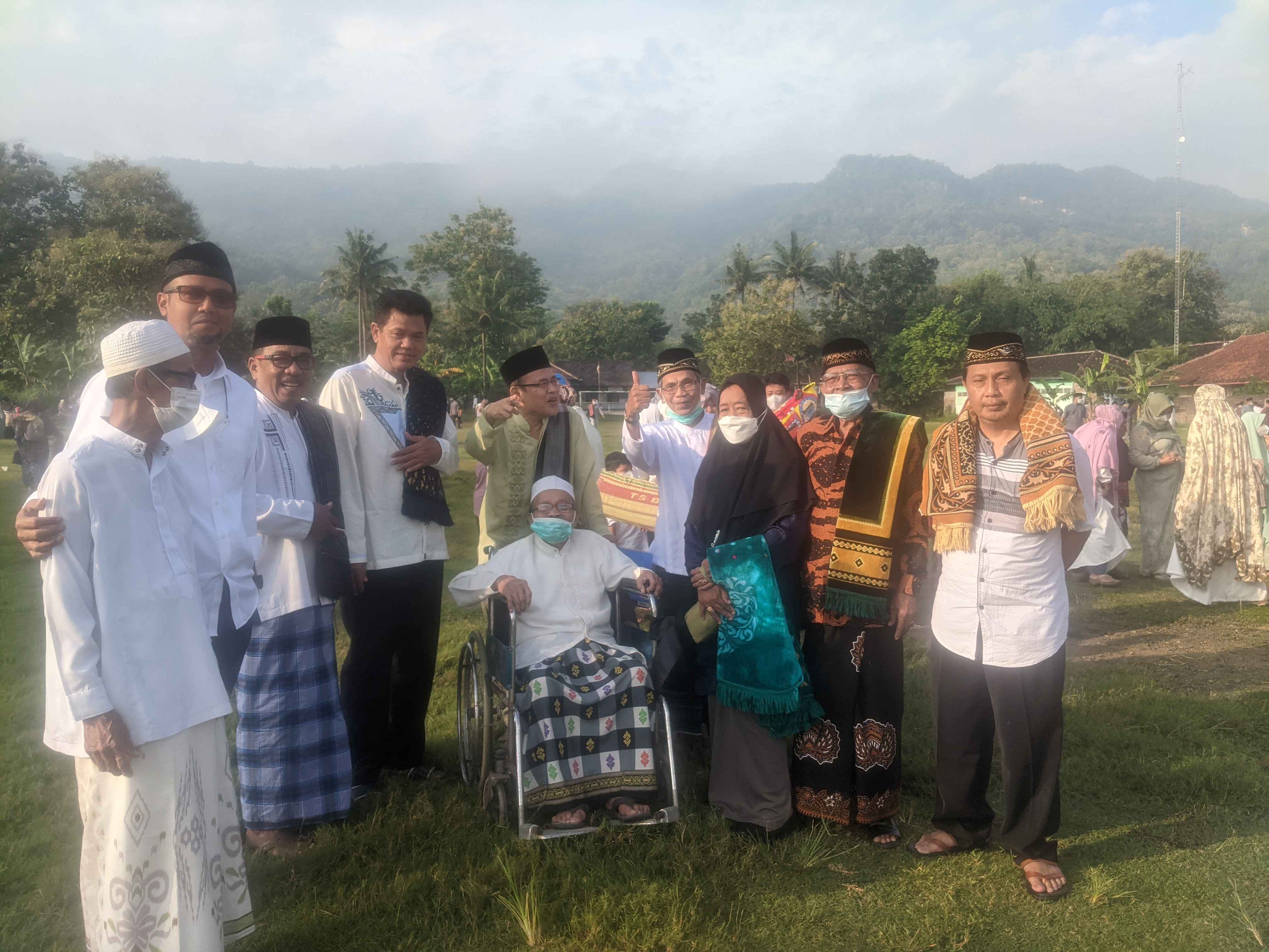 Para sesepuh berfoto.  Tampak bukit batu karang jauh di belakang mereka. Setelah salat Ied siap melakukan ritual adat di lokasi yang sudah ditentukan.