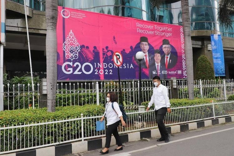 Sejumlah ASN KKP melintasi poster dukungan dalam rangka menyambut perhelatan G20 di Bali Oktober mendatang/Dok. Humas Kementerian KKP