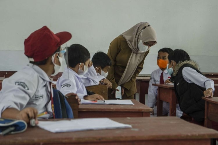 Guru mengajarkan murid pada pelaksanaan pembelajaran tatap muka di SDN 065 Cihampelas, Bandung, Jawa Barat, Senin (10/1/2022)| ANTARA FOTO/NOVRIAN ARBI