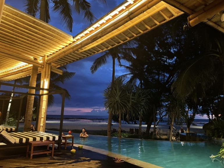 PENGUNJUNG BERENANG. Pengunjung hotel di Gili Trawangan berenang dan menikmati pemandangan setelah matahari terbenam, Kamis (5/5). (Chelsea Anastasia)