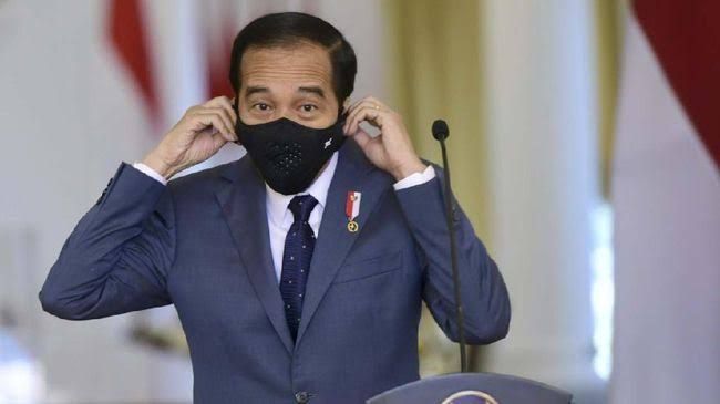 Presiden Jokowi sedang membuka masker saat melakukan konferensi pers/Foto: CNN Indonesia
